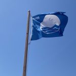 2023 Blue Flag USA flag (dark blue flag, white circle with blue waves, and the number 2023) waving high in the sky